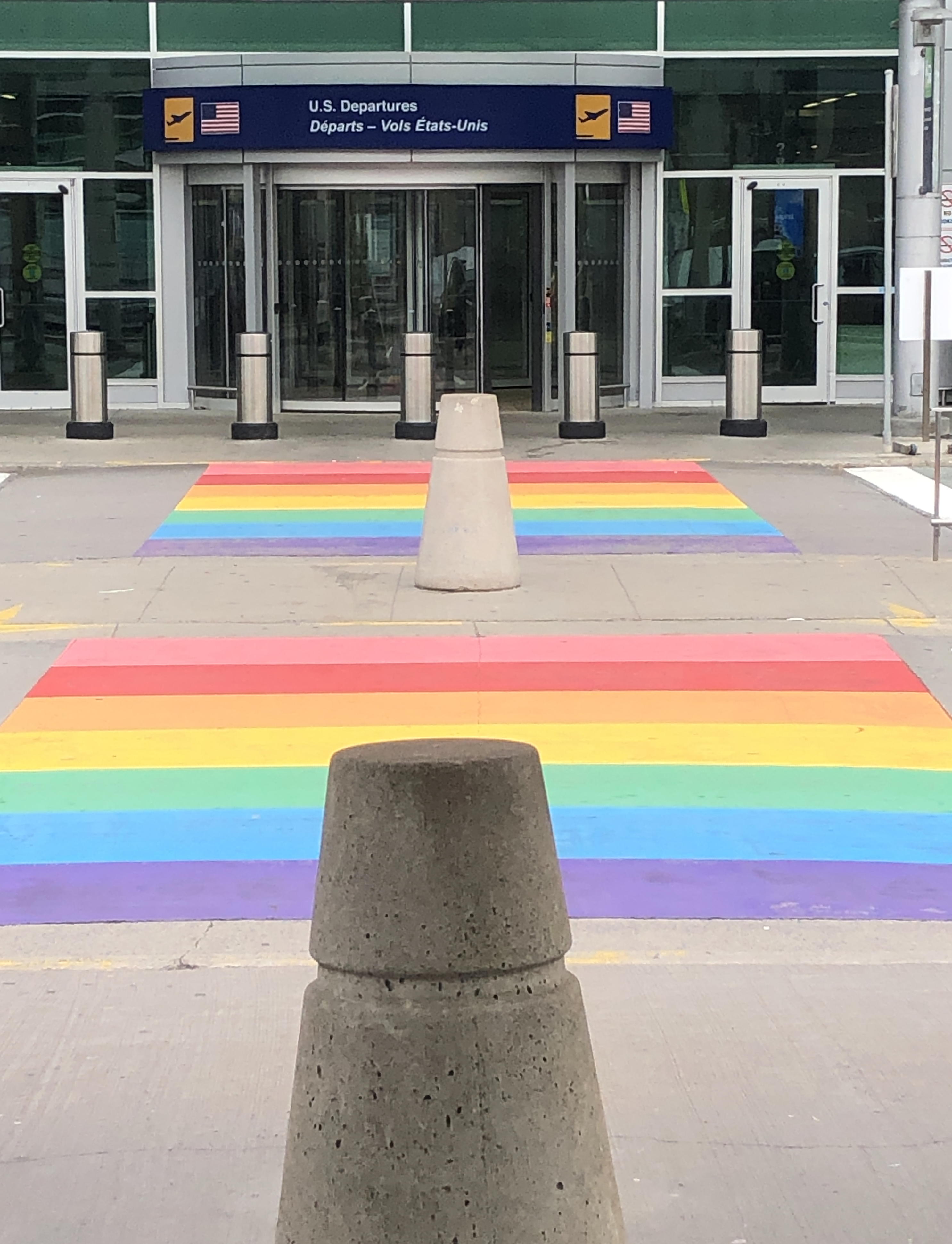 Rainbow sidewalk and airport "US Departures" entrance