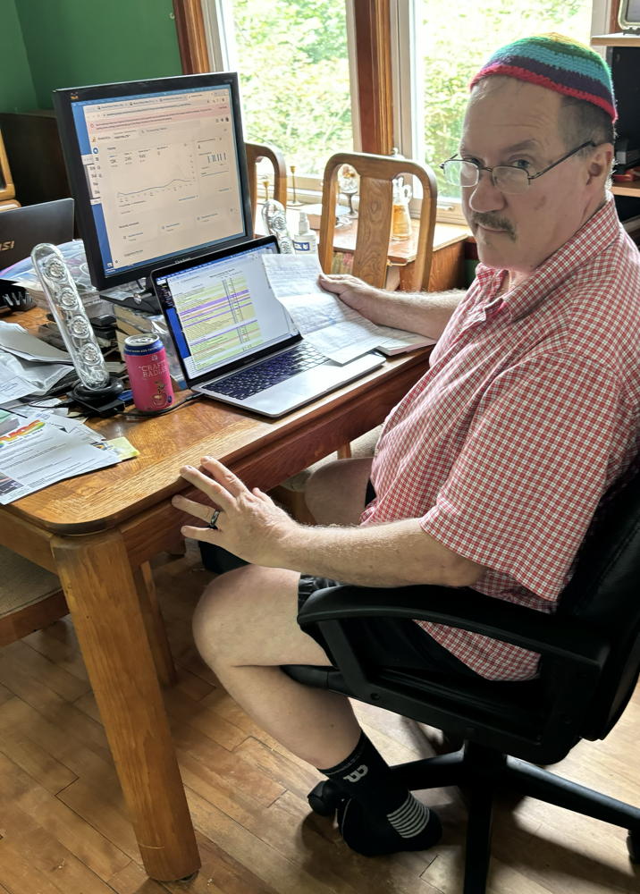 Dan sitting at computer with handwritten note in hand