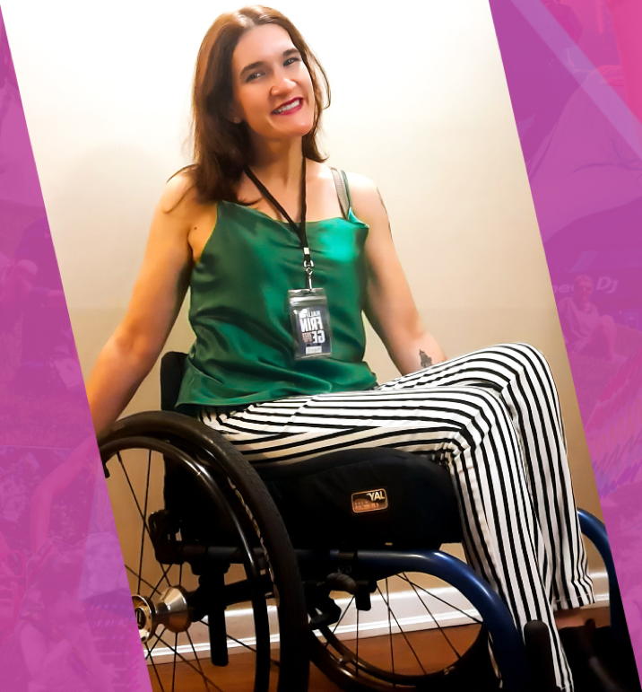 Smiling woman in wheelchair, green top, black and white striped pants