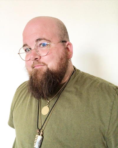 young man with beard and round glasses