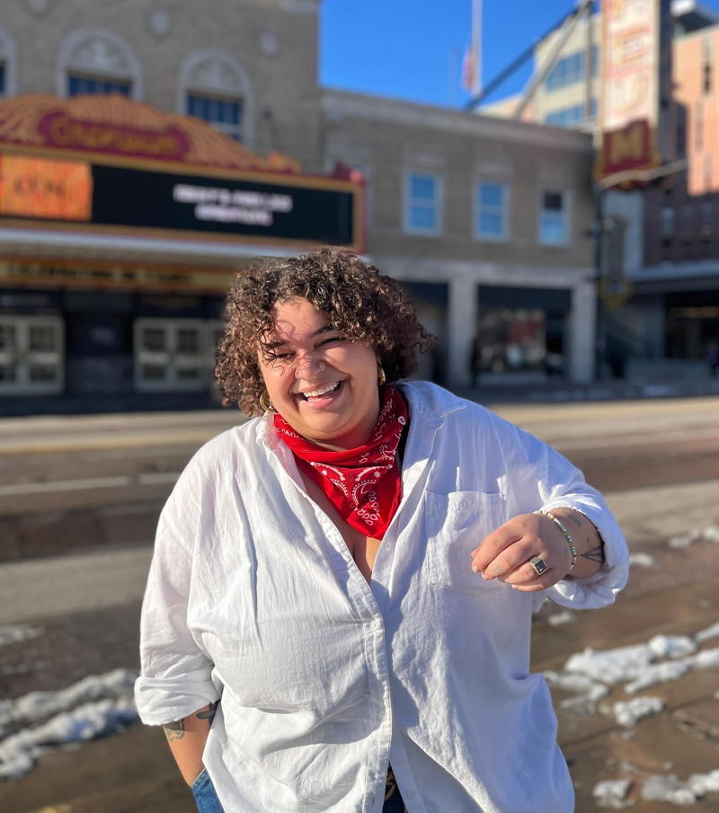 joce on city street, white collar shirt and red paisley kerchief around her neck