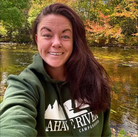 owner Jamie Lee selfie with the small lake and fall colurs behind her