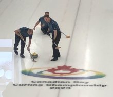 Toronto team curling near the organization's logo